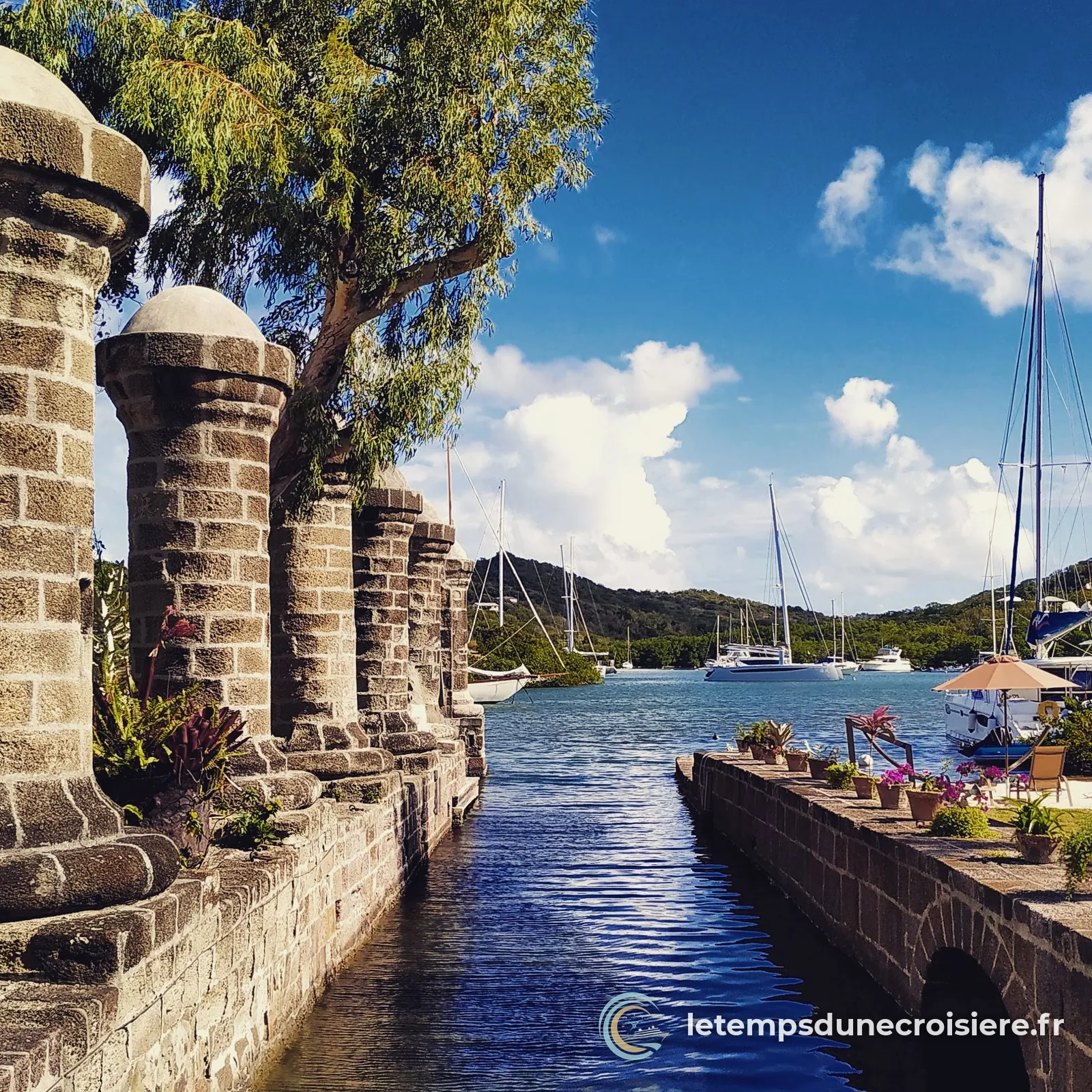 Les piliers de pierre de Nelson's Dockyard, à Antigua, et les voiliers au fond