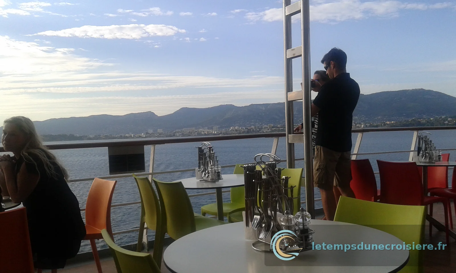 La terrasse du restaurant avec ses chaises colorées et vue sur la côte